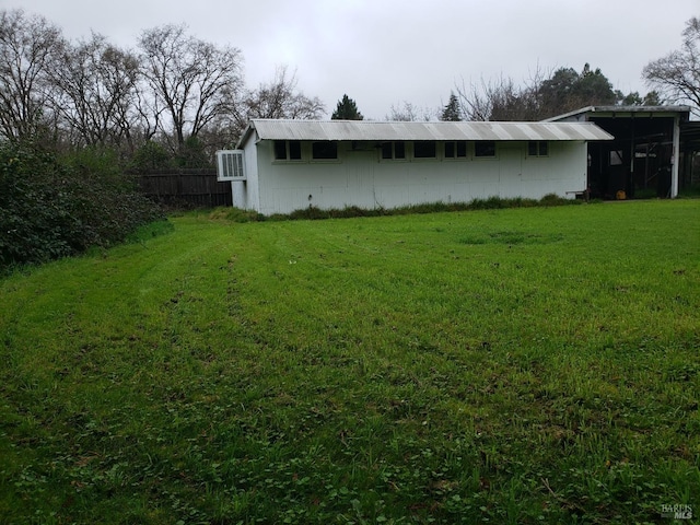 view of property exterior featuring an outbuilding and a lawn