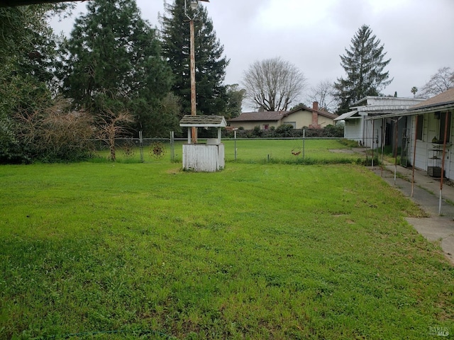 view of yard with a carport and fence