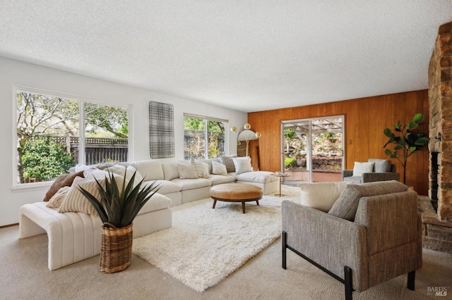 carpeted living room featuring wood walls and a textured ceiling