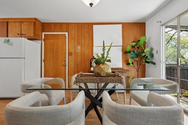 dining room with wooden walls and wood finished floors