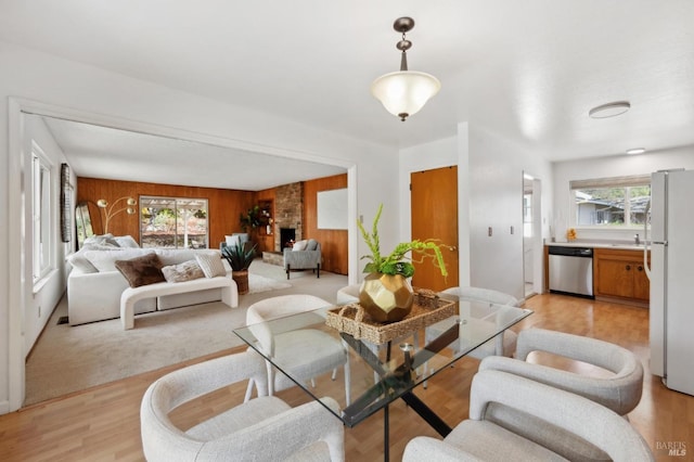 living area with wood walls and light wood-style flooring