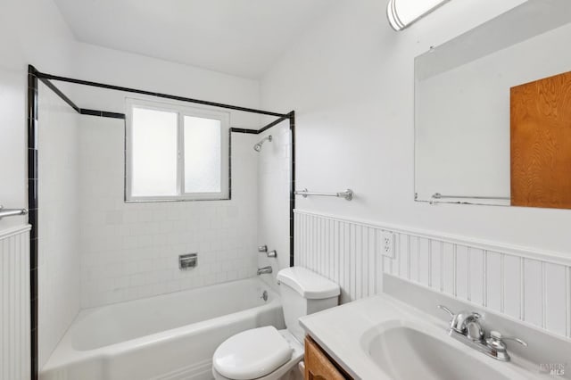 full bathroom with wainscoting, vanity, toilet, and shower / bathtub combination