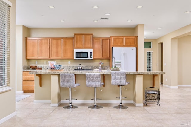 503 Twin Lakes Ln, Rio Vista, CA 94571 - kitchen with visible vents, white appliances, light tile patterned flooring, and a center island with sink