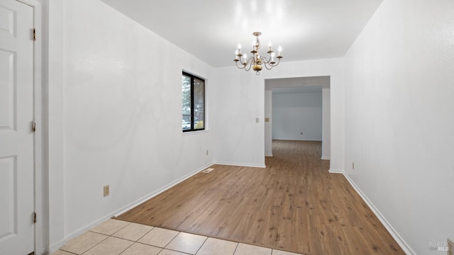 unfurnished dining area with baseboards, a chandelier, and tile patterned flooring