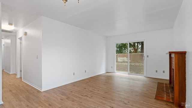 empty room with light wood-style flooring and baseboards