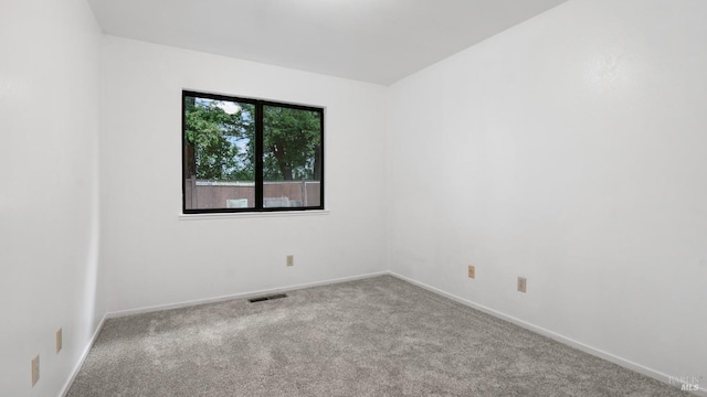 carpeted empty room featuring visible vents and baseboards