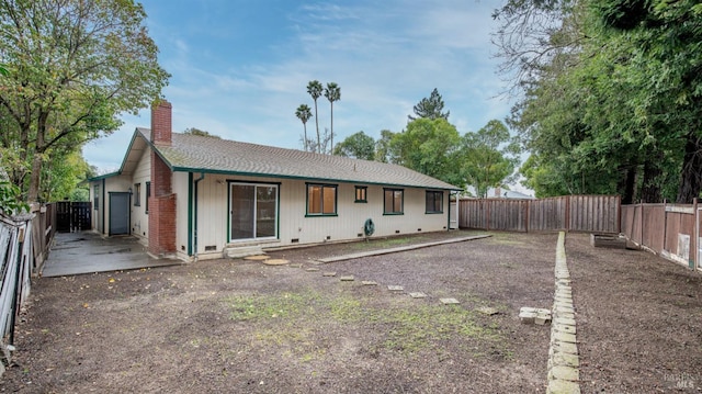 back of property with a fenced backyard and a chimney