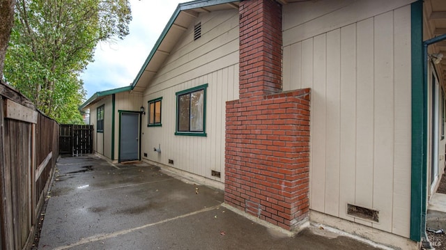 view of side of property featuring a patio area, a fenced backyard, and crawl space