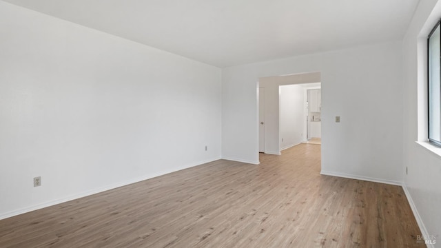 unfurnished room with baseboards and wood finished floors