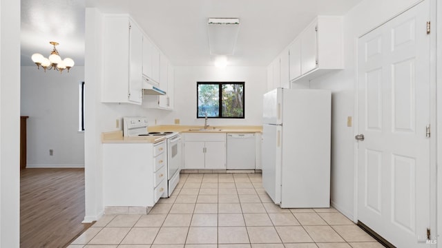 kitchen with white appliances, light tile patterned floors, a sink, light countertops, and white cabinetry