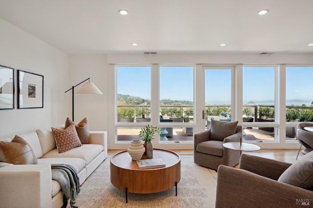 living room featuring recessed lighting, visible vents, and light wood finished floors