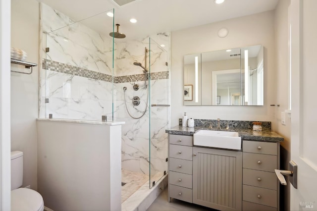 full bathroom with a marble finish shower, recessed lighting, toilet, and vanity
