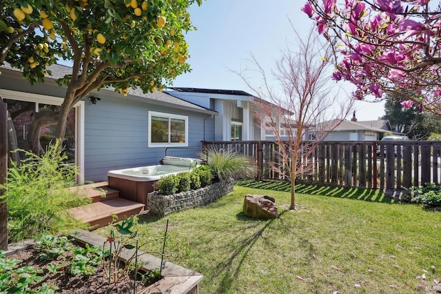 view of yard with a hot tub and fence