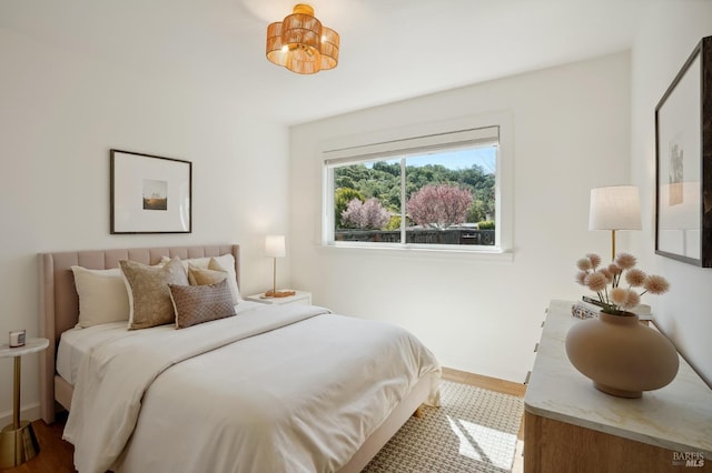 bedroom with baseboards and wood finished floors