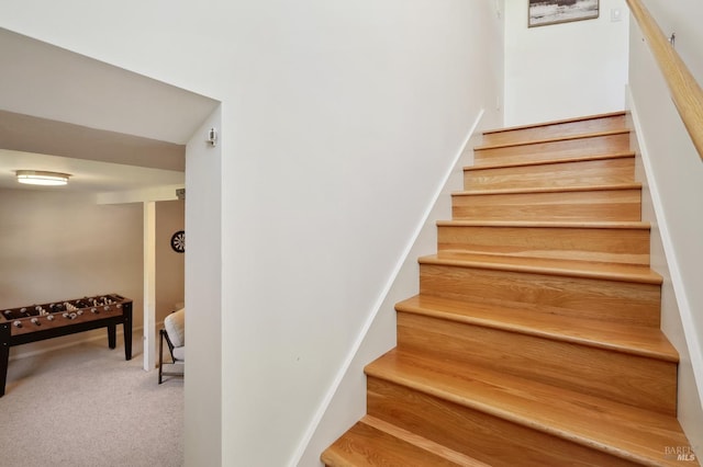 staircase featuring carpet