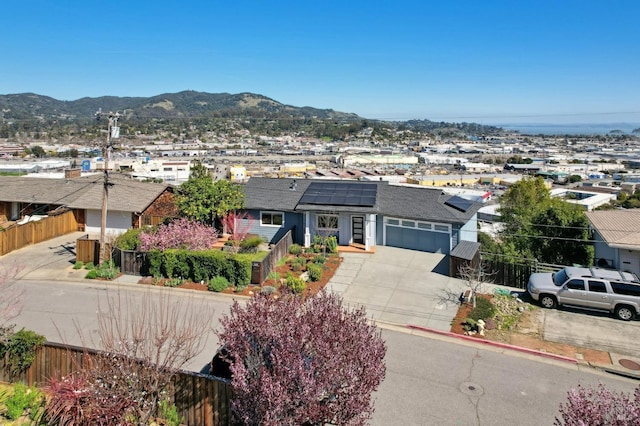 exterior space featuring a mountain view, concrete driveway, a garage, and fence