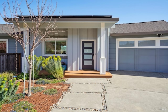 entrance to property featuring an attached garage, board and batten siding, and driveway