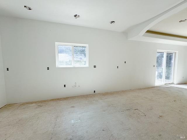 unfurnished room featuring arched walkways