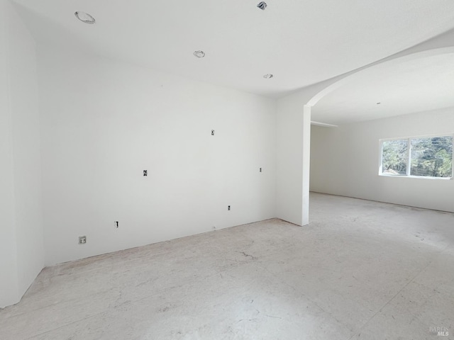 empty room featuring arched walkways