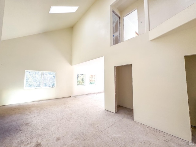 empty room with a skylight and high vaulted ceiling