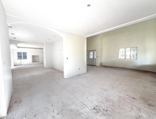 empty room featuring arched walkways and concrete floors