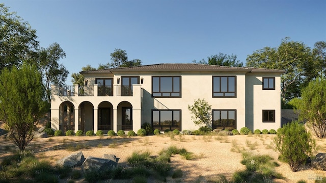 back of property with stucco siding and a balcony