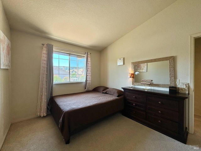 carpeted bedroom with lofted ceiling and a textured ceiling