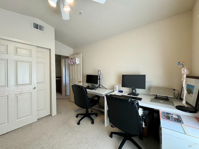 office area featuring a ceiling fan, vaulted ceiling, light colored carpet, and visible vents