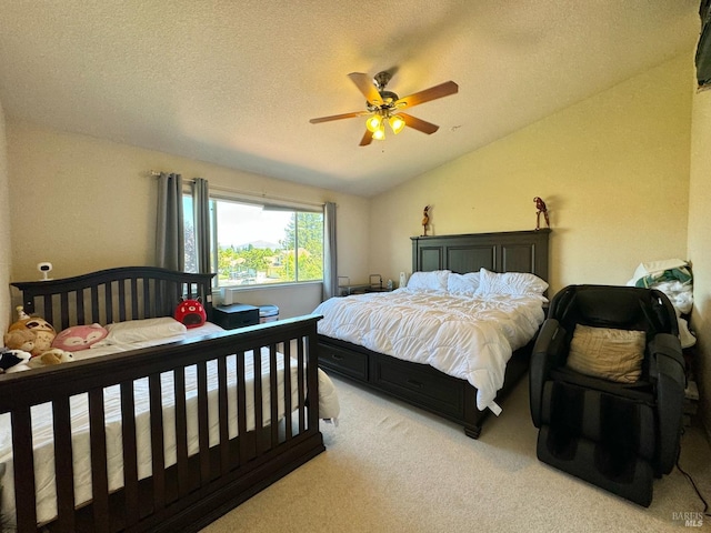 carpeted bedroom featuring lofted ceiling, a textured ceiling, and ceiling fan