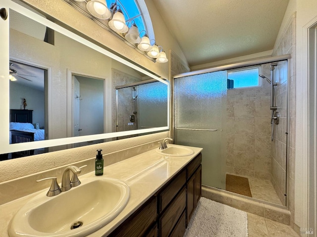 ensuite bathroom featuring double vanity, a shower stall, connected bathroom, and a sink