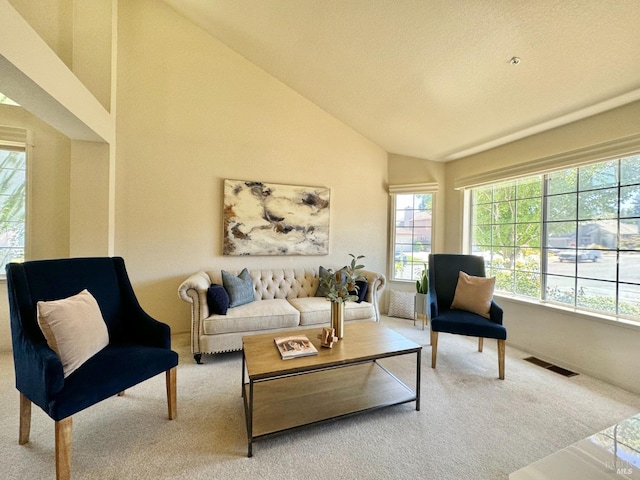 carpeted living room featuring visible vents and high vaulted ceiling