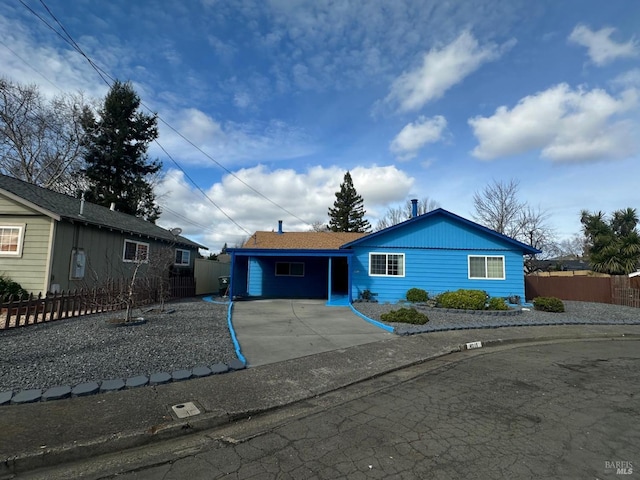 ranch-style house with concrete driveway and fence
