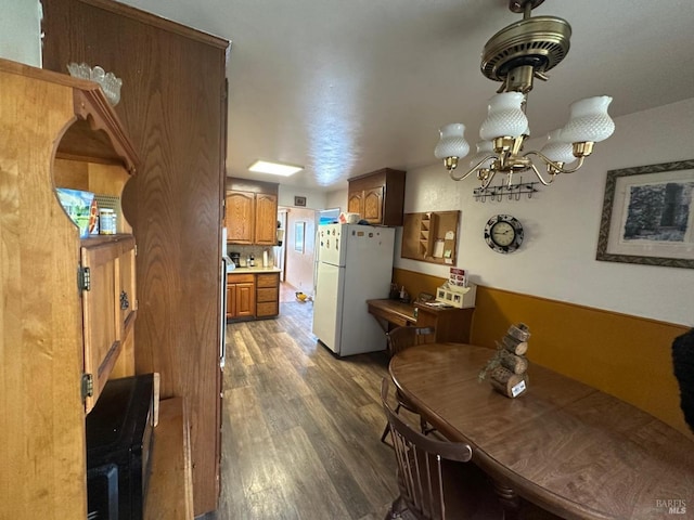 dining space with wood finished floors and a chandelier