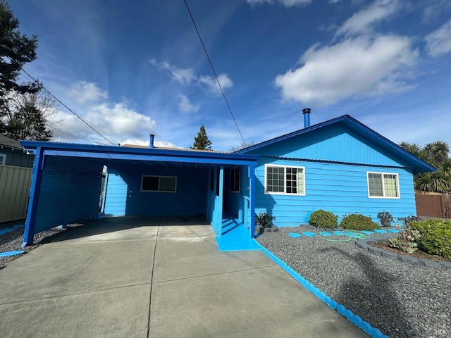 single story home featuring an attached carport, driveway, and fence