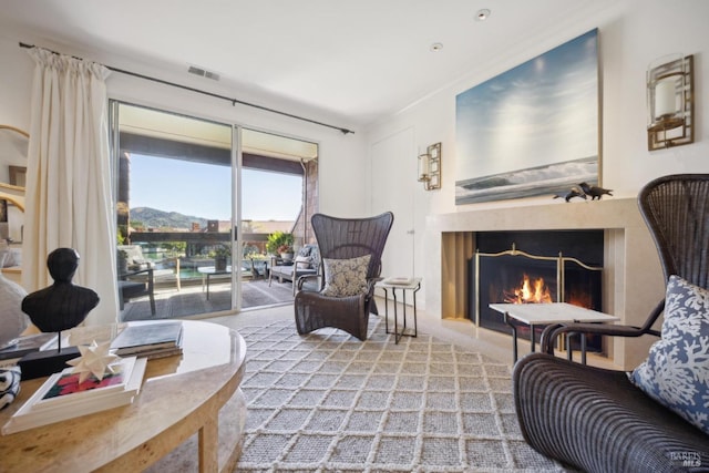 living room featuring a lit fireplace and visible vents
