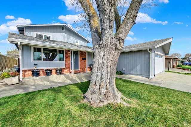 view of front of house featuring a front yard, an attached garage, driveway, and roof with shingles