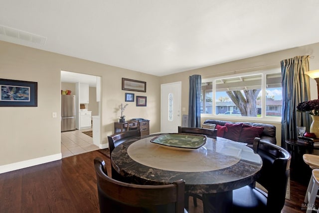 dining space featuring visible vents, baseboards, and wood finished floors