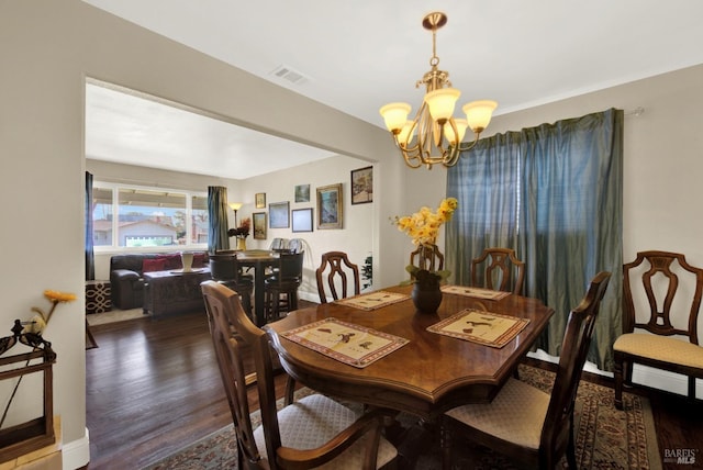 dining room with visible vents, an inviting chandelier, and wood finished floors