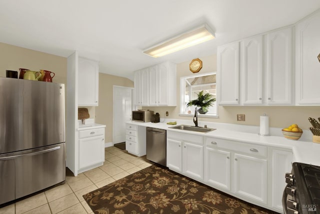 kitchen with light tile patterned floors, white cabinetry, appliances with stainless steel finishes, light countertops, and a sink