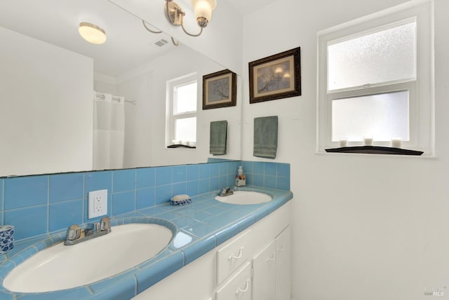 full bath featuring a sink, visible vents, double vanity, and curtained shower