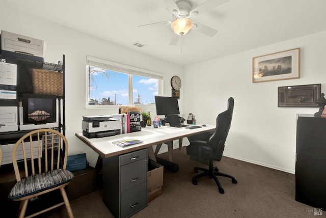 office area featuring visible vents, baseboards, dark carpet, and ceiling fan