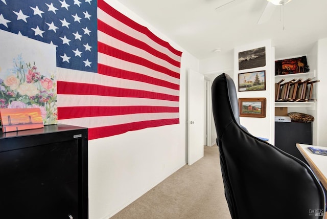 carpeted office space featuring ceiling fan