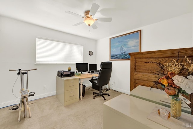 home office featuring light carpet, baseboards, and a ceiling fan