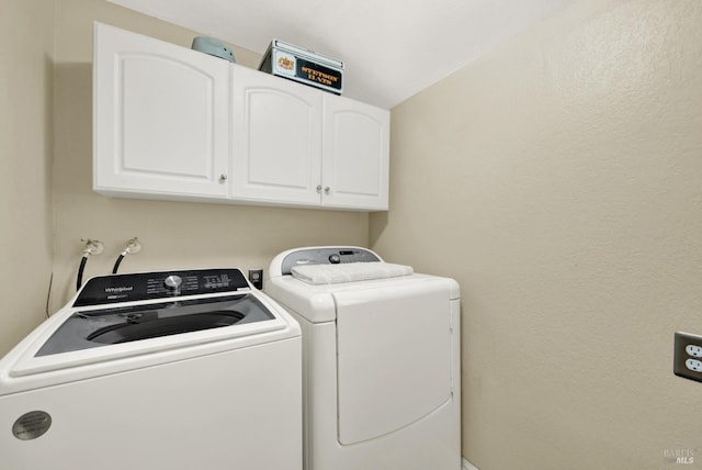 washroom featuring cabinet space and washer and clothes dryer