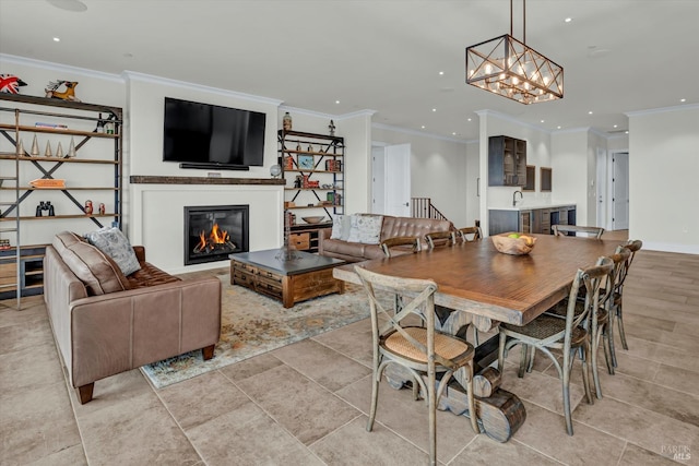 dining room with a glass covered fireplace, baseboards, a chandelier, recessed lighting, and crown molding