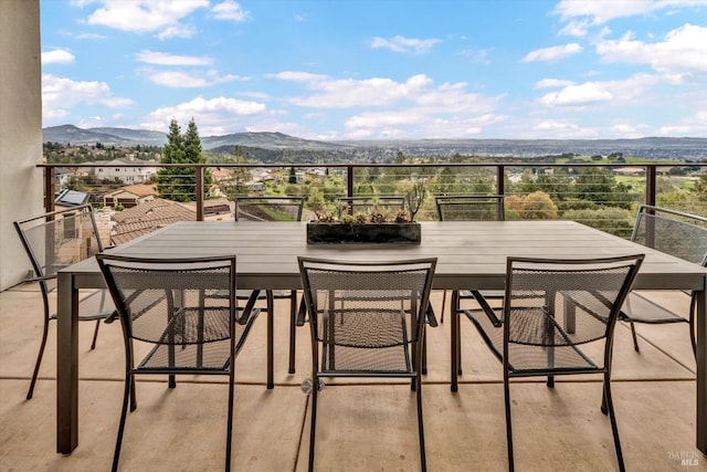 balcony with a mountain view and outdoor dining space