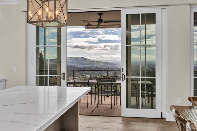 dining space featuring ceiling fan with notable chandelier and a mountain view