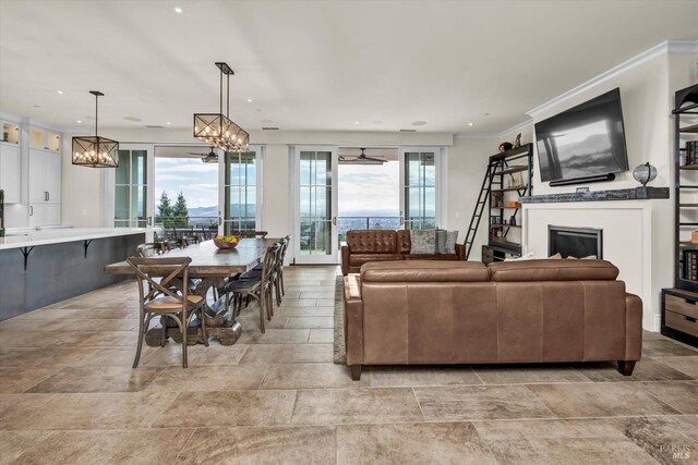 living area featuring recessed lighting, a fireplace, a notable chandelier, and ornamental molding