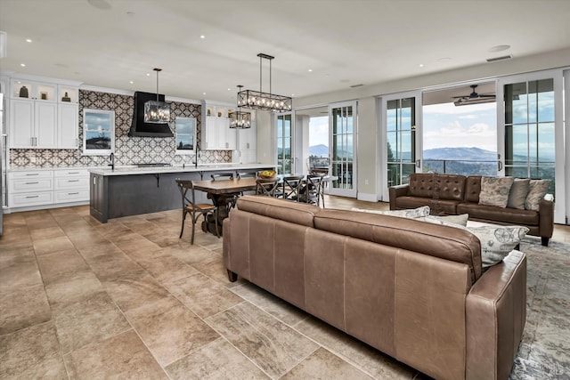 living room with a chandelier, recessed lighting, visible vents, and crown molding