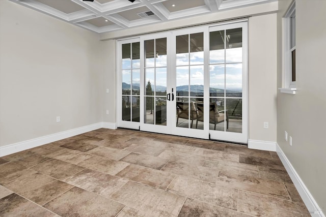 empty room featuring coffered ceiling, a mountain view, baseboards, and plenty of natural light